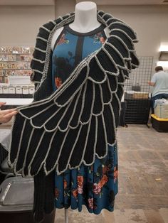 a mannequin dressed in black and blue with chains on it's arms