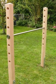 two wooden poles with holes in the grass