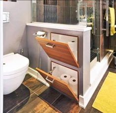 a bathroom with a toilet, sink and shower stall that is built into the wall