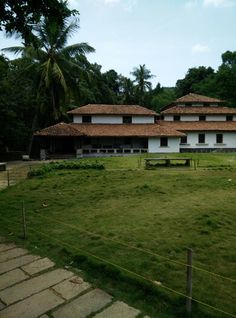 an old house sits in the middle of a lush green field