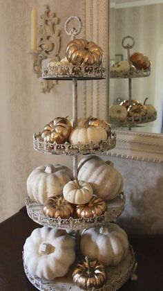 a three tiered tray with pumpkins on it