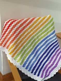 a crocheted blanket sitting on top of a wooden chair