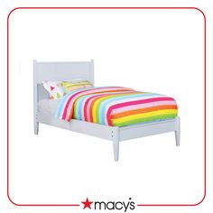 a white bed with multi colored sheets and pillows on it's headboard, in front of a white background