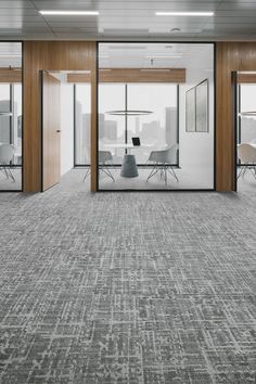 an empty conference room with glass walls and chairs