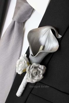 a boutonniere with a flower on it is attached to the lapel of a suit