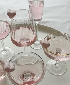 several wine glasses with hearts on them are sitting on a table next to each other