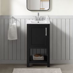 a bathroom with a sink, mirror and towel rack on the wall next to it