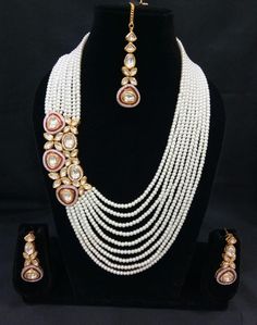 The base metal color is Gold tone studded with white kundan stone . This jewellery set consists of a necklace and a matching pair of earrings and a mangtika Off-white gold-plated beaded and kundan-studded layered necklace, secured with drawstring closure A pair of matching drop earrings, secured with a post and back closure White Jewelry For Diwali Festival, White Chandbali Bridal Sets For Celebration, White Hand-set Temple Jewelry Sets, White Pearl Jewelry Sets For Diwali, Festive White Pearl Necklace With Pearl Chain, White Temple Jewelry Bridal Sets For Festivals, White Jewelry Sets For Wedding And Diwali, White Temple Jewelry Sets For Festive Occasions, Festive White Jewelry