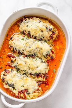 chicken parmesan in a white casserole dish with tomato sauce and cheese