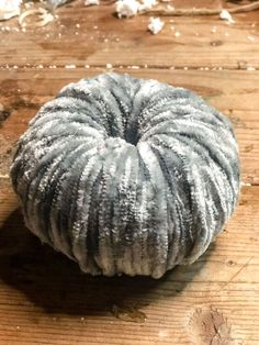 a round object sitting on top of a wooden table covered in frosty snowflakes