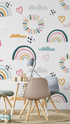 two chairs and a table in front of a wall with rainbows