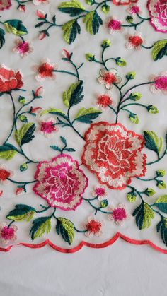 an embroidered table cloth with flowers on it