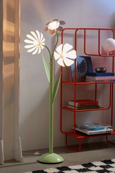 a lamp that is on top of a shelf next to a flower pot and books