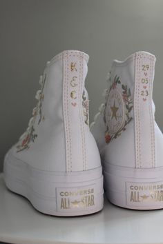 a pair of white converse sneakers with flowers and stars on the soles are shown