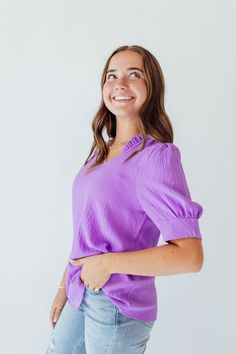 Indulge in the vibrant and joyful energy of Amy In Purple. The ruffle v-neck and banded sleeves add a playful touch to this elegant design. With its stunning purple hue, this piece is sure to brighten up your wardrobe and your day. Fits true to size. Model is wearing a small and is 5'3". Model in try on video is wearing a 2X and is 5'11". Size Chart Length Bust S 24" 38" M 24" 40" L 25" 42" 1x 26" 46" 2x 27" 48" 3x 27" 52" *All measurements are approximate and done while hanging.* Fabric and Car Chic Purple Puff Sleeve Blouse, Purple Ruffle Sleeve Spring Top, Elegant Lavender V-neck Blouse, Feminine Lavender V-neck Blouse, Trendy Purple Ruffled Blouse, Trendy Purple Blouse With Ruffles, Spring Lavender V-neck Blouse, Purple V-neck Top With Ruffles, Lavender V-neck Blouse For Spring