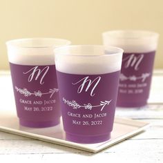 three shot glasses with the names and date printed on them, sitting on a tray