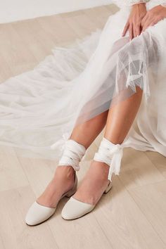 The gorgeous Philippa ballet flats are handmade of top-quality leather featuring our signature silk ankle ties and comes with an alternative plain ankle strap, too. This romantic style has a rounded closed toe, open waist at the sides and you can choose the color combo (leather/laces) that matches with your wedding dress. They are ideal for brides looking for simple wedding flat shoes that will keep them feeling comfy and confident all day long. Also Ideal for bridesmaids who prefer a flat. White Flat Bridesmaid Wedding Shoes, White Ankle Tie Heels For Wedding, Wedding Heels With Wrapped Heel And Ankle Tie, Ankle Tie Heels With Wrapped Heel For Wedding, Spring Wedding Heels With Ankle Tie, White Flat Heel Wedding Shoes For Bridesmaids, White Flat Heel Bridesmaid Wedding Shoes, Spring Wedding Shoes With Wrapped Heel, Spring Wedding Ballet Flats With Ankle Strap