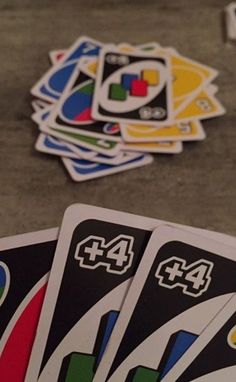 four playing cards sitting on the ground next to each other with numbers printed on them