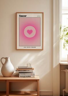 a white vase sitting on top of a wooden table next to a wall mounted poster