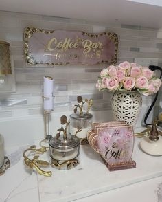 a kitchen counter topped with pink roses and coffee cups