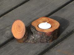 a candle that is sitting on top of a piece of wood