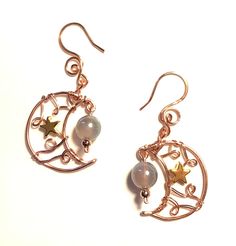 "Crescent moon earrings are made out of Copper wire with copper swirly loop designs and a gold star bead inside the moon.   There's a dangling round Opalite moondust glass bead with AB - Aurora Borealis luster.   Drop length is 2\" , diameter of moon is 1\"." Wire Wrapped Moon Shaped Earrings, Gold Moon Shaped Wire Wrapped Earrings, Crystal Ball Earrings, Chainmaille Bracelet, Crescent Moon Earrings, Star Earrings Stud, Gold Moon, Moon Earrings, Gold Star