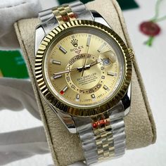 This timepiece is a Rolex Sky-Dweller, distinguished by its two-tone Oystersteel and 18ct yellow gold construction. The champagne dial features the iconic off-center 24-hour disc for dual time zone display, and an annual calendar. The watch is powered by the Calibre 9001, a complex self-winding mechanical movement. The fluted bezel, Oyster bracelet with Easylink extension, and Superlative Chronometer certification exemplify Rolex's commitment to precision and luxury. This Sky-Dweller is a sophis Designer Gold Watches With Chronometer, Luxury Automatic Yellow Gold Watch, Luxury Yellow Gold Automatic Watch, Designer Gold Watches With Subdials, Gold Diamond Watch With Round Dial For Business, Gold Diamond Business Watch, Gold Diamond Watch For Business, Gold Chronometer Watch Accessories With Round Dial, Gold Diamond Watch With Chronometer And Round Dial