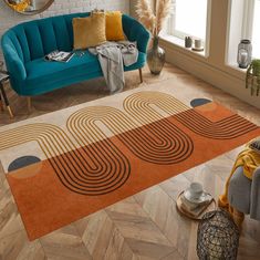 a living room with a blue couch and orange rug on the floor next to a window