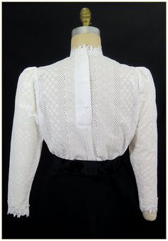 "100% Cotton. Color: White. Embroidered stripe pattern weave cotton fabric with white poly floral leaf lace trim. Poly trim for collar, cuffs and front bodice, classic Edwardian design. Lightly gathered full length sleeves with button back. Generously cut for comfort. Machine washable. Circa 1898-1910. Made in U.S.A. Sizes: SM, MED, LG & XLG. Blouses ordered by bust measurement, inches: BUST SIZES 32\" - 34\" SMALL 35\" - 39\" MEDIUM 40\" - 44\" LARGE 45\" - 49\" XLARGE Blouses ordered by bu Elegant Cotton Lace Patchwork Tops, Victorian Cotton Fitted Blouse, Fitted Victorian Cotton Blouse, Fitted Broderie Anglaise Blouse, Fitted Blouse With Broderie Anglaise, Elegant Cotton Lace Blouse For Spring, Elegant Cotton Top With Lace Patchwork, White Cotton Blouse With Lace Cuffs, Fitted Classic Tops With Broderie Anglaise