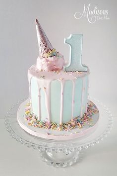 a birthday cake decorated with sprinkles and an ice cream cone on top