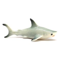 a toy shark sitting on top of a white surface