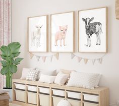 three framed pictures hang on the wall above a bench in a room with pink curtains