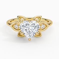 a heart shaped diamond ring with wings on the band and side stones in yellow gold