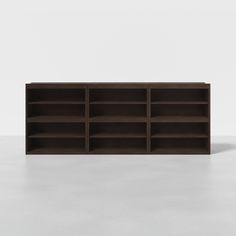 an empty bookcase on a white surface with no people around it, and the shelves are