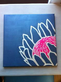 a blue and pink painting on the wall above a white table with a red flower painted on it