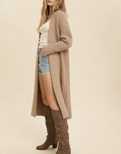 The Fireside Knit Duster is a slightly oversized fit. This is a thick knit cardigan with folded sleeves. 47% Polyester, 26.5% Acrylic, 26.5% Nylon. Model is wearing a size Small.