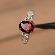 It is a natural garnet ring. The main stone is 7mm*9mm oval cut, weight about 2.33 carats. The basic metal is sterling silver and plated with rhodium. To change the metal to a solid gold (white/rose) or platinum is also available, please ask for a quotation if you want. You can also go to my shop Home for more elegant rings: https://www.etsy.com/shop/godjewelry?ref=hdr_shop_menu More natural garnet rings: https://www.etsy.com/shop/godjewelry?ref=seller-platform-mcnav&section_id=20709242 Cust Butterfly Engagement Ring, Exclusive Engagement Rings, Rings Pandora, Garnet Wedding Rings, White Gold Promise Ring, January Birthstone Rings, Garnet Engagement Ring, Red Garnet Ring, Handmade Jewelry Ring