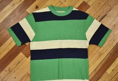 You are looking at a vintage t-shirt circa 1960s-70s. Striped 100% cotton. This shirt is in nicely "worn in" condition with signs of usage throughout. There are two repairs, one on front and one on back (lower), shown in photos. See photos for overall detail. Seems to fit a size small. Please see measurements to ensure proper fit. Measurements (laying flat): 27.5" top of collar to bottom in back 17" pit to pit Vintage Green Cotton Tops, Vintage Green Crew Neck Top, Green Vintage Crew Neck Top, 1970s Cotton Short Sleeve Tops, 1970s Style Cotton Short Sleeve Tops, 1970s Style Cotton Tops With Short Sleeves, Icelandic Sweaters, Striped T Shirt, Wool Plaid