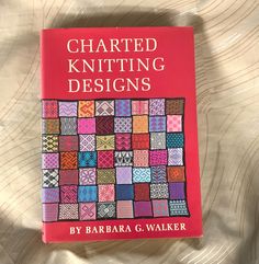 a red book with an image of a quilt on it's cover that reads, chartered knitting designs