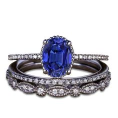 an oval shaped blue sapphire and diamond ring with matching band, set on white background