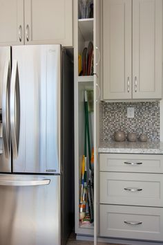 a kitchen with white cabinets and stainless steel appliances