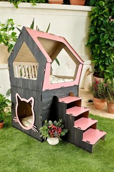 a cat house made out of pallet wood with stairs leading up to the top