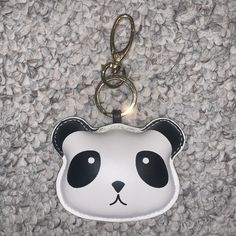 a panda bear keychain with a black and white face on it's side