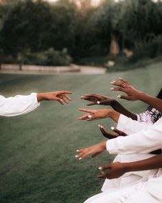 several people reaching out their hands to each other