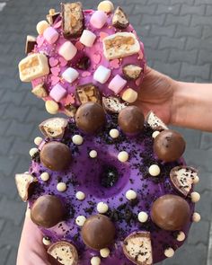 a donut covered in chocolate and marshmallows on top of a purple doughnut