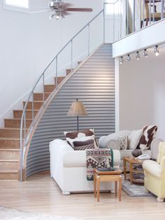 a living room filled with furniture and a stair case