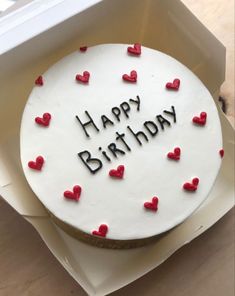 a white birthday cake with red hearts on it