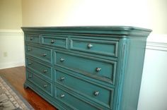 an old dresser is painted teal green