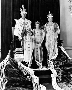 an old black and white photo of two people in fancy clothing standing next to each other