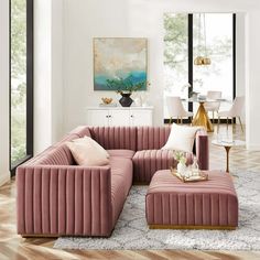 a living room with pink couches and white chairs in front of a large window